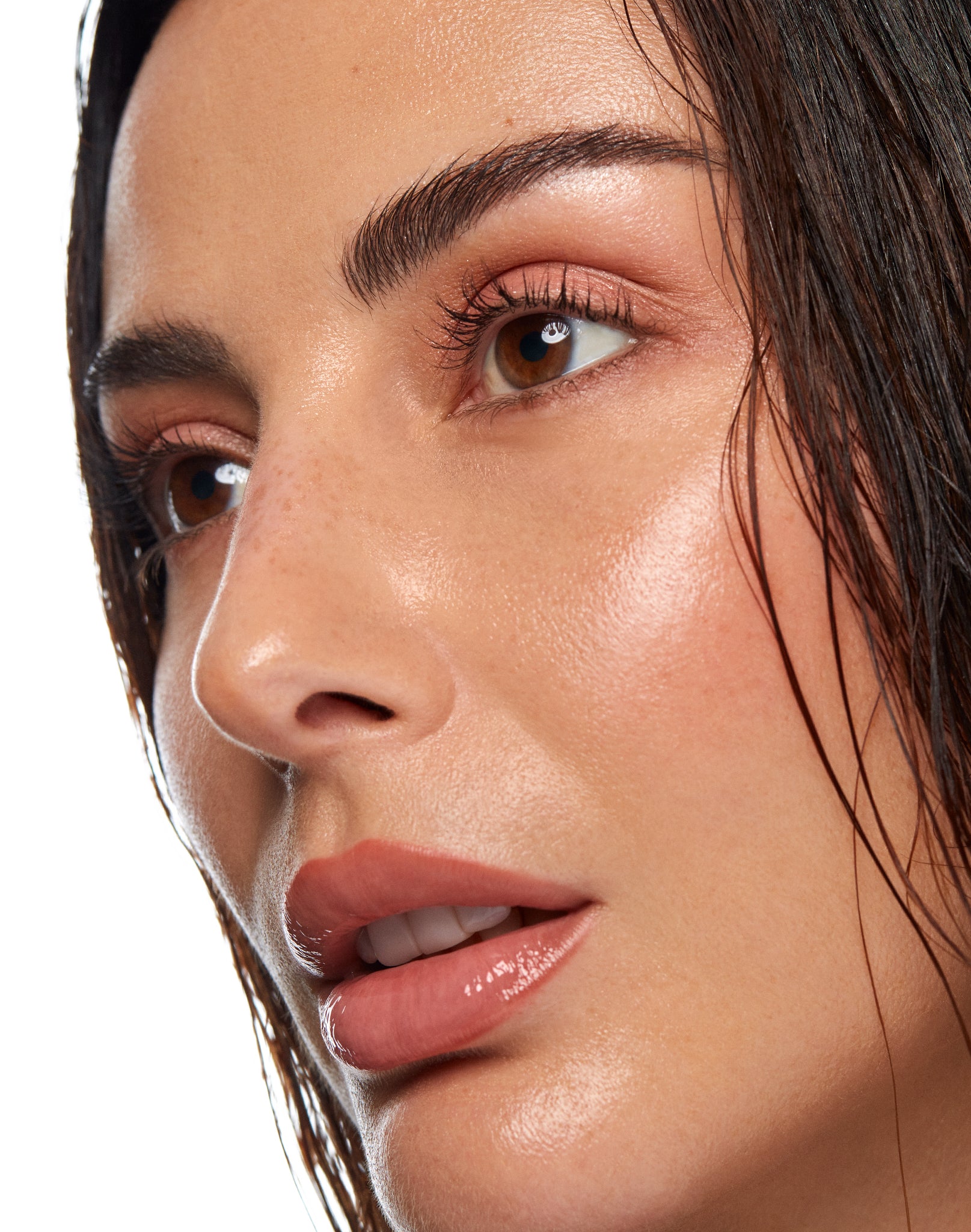 Close-up of a woman's face highlighting glowing, radiant skin and a dewy complexion.