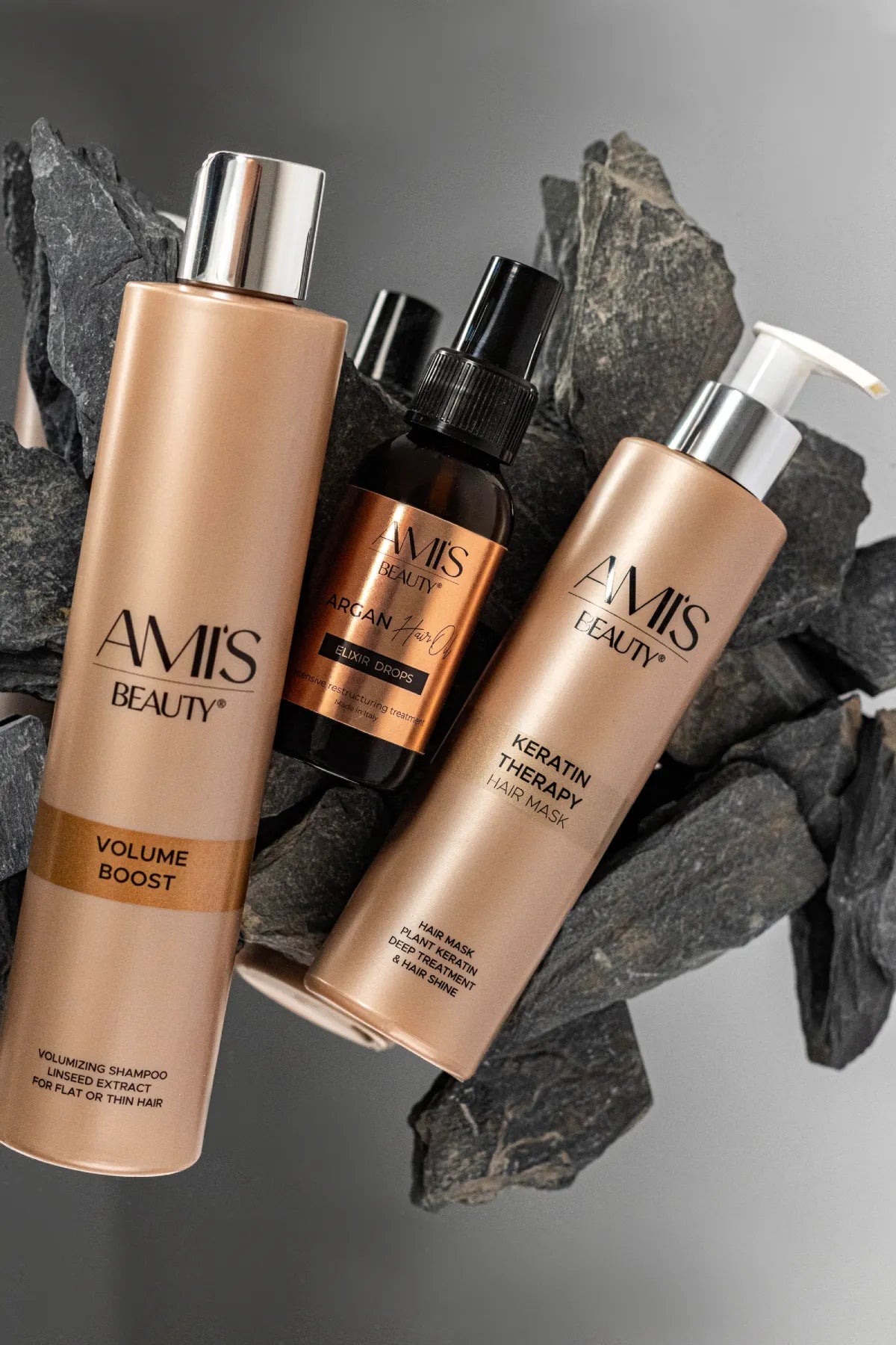 Artistic overhead shot of the Extra Volumizing Boost Set bottles arranged on a dark, textured slate background with coffee beans.