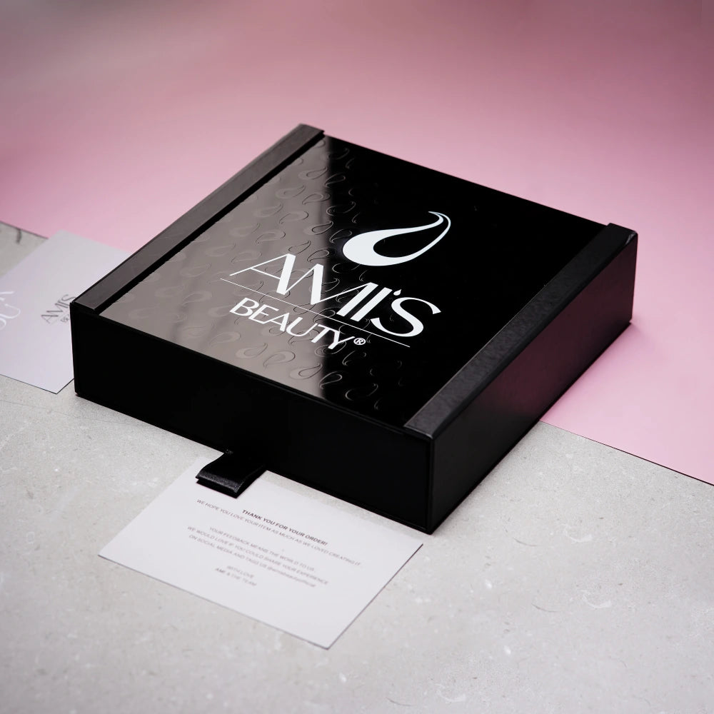 Square black Personalized Gift Box featuring the Amis Beauty logo on a soft pink background.