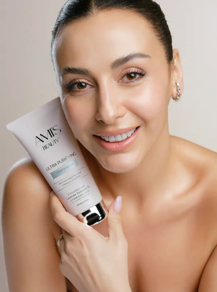 Smiling woman with bare shoulders holding a tube of Ultra Purifying Cleansing Gel close to her face.