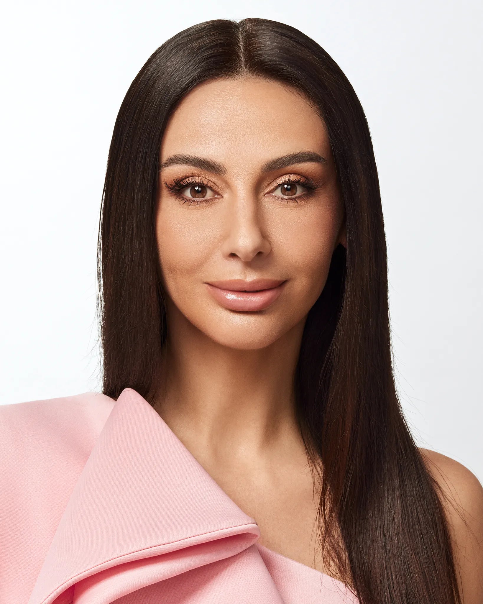 Portrait of a woman with long straight dark hair wearing a pink top.